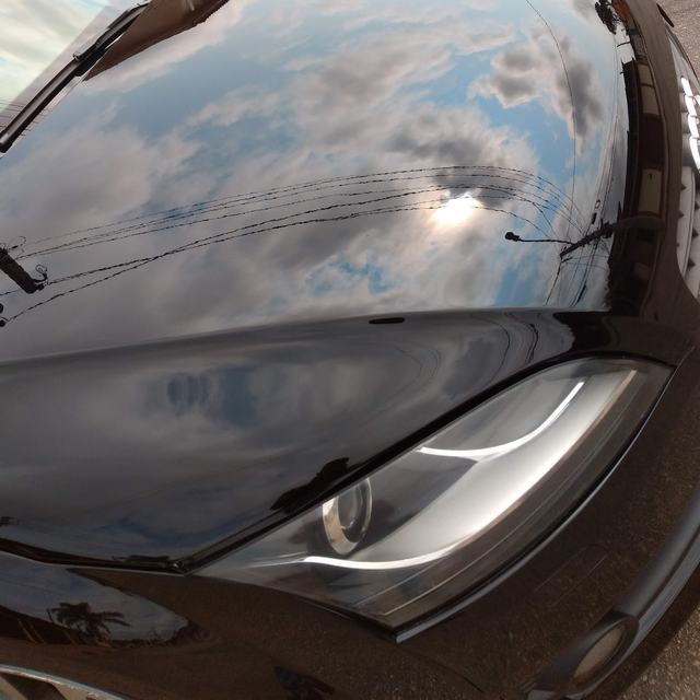 Capô preto polido refletindo o céu como um espelho